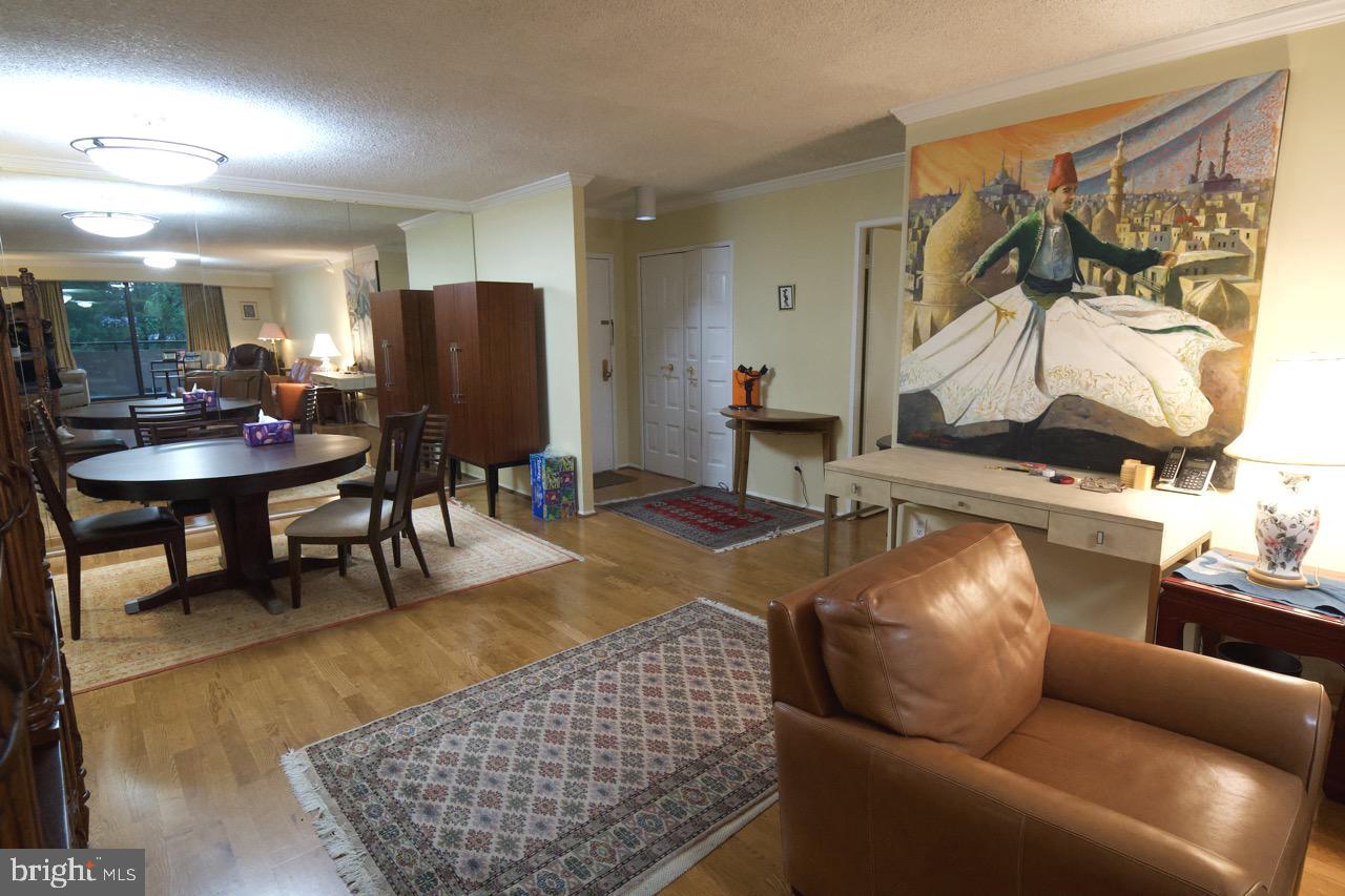 1800 Old Meadow Road, Unit 818 McLean, VA 22102 - Photo 13 of 35 a living room with furniture a rug and white walls