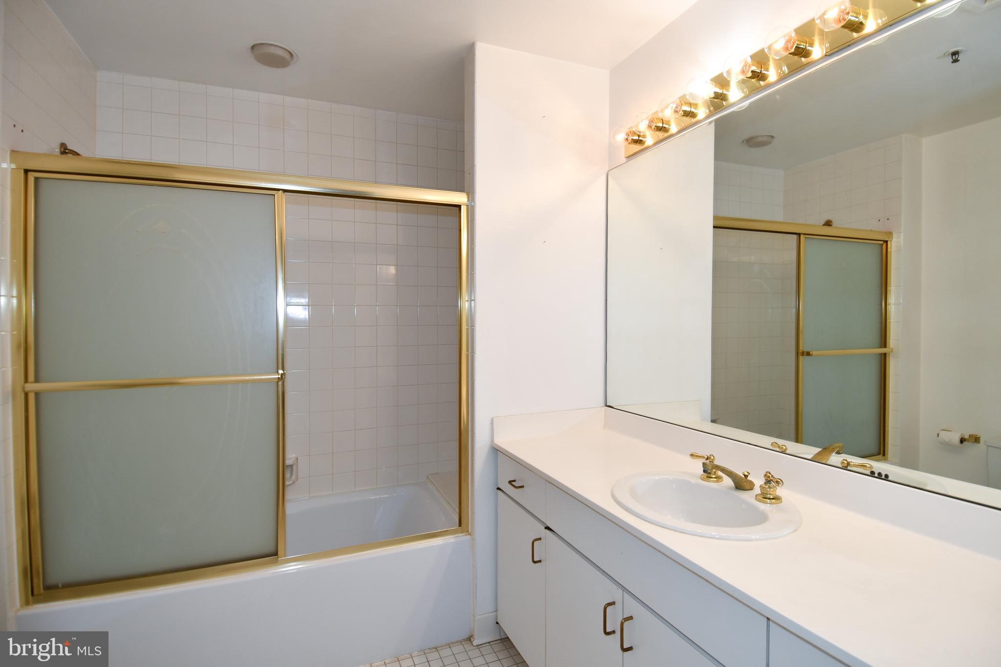 10 East Lee Street, Unit 809 Baltimore, MD 21202 - Photo 27 of 58 a bathroom with a double vanity sink and mirror