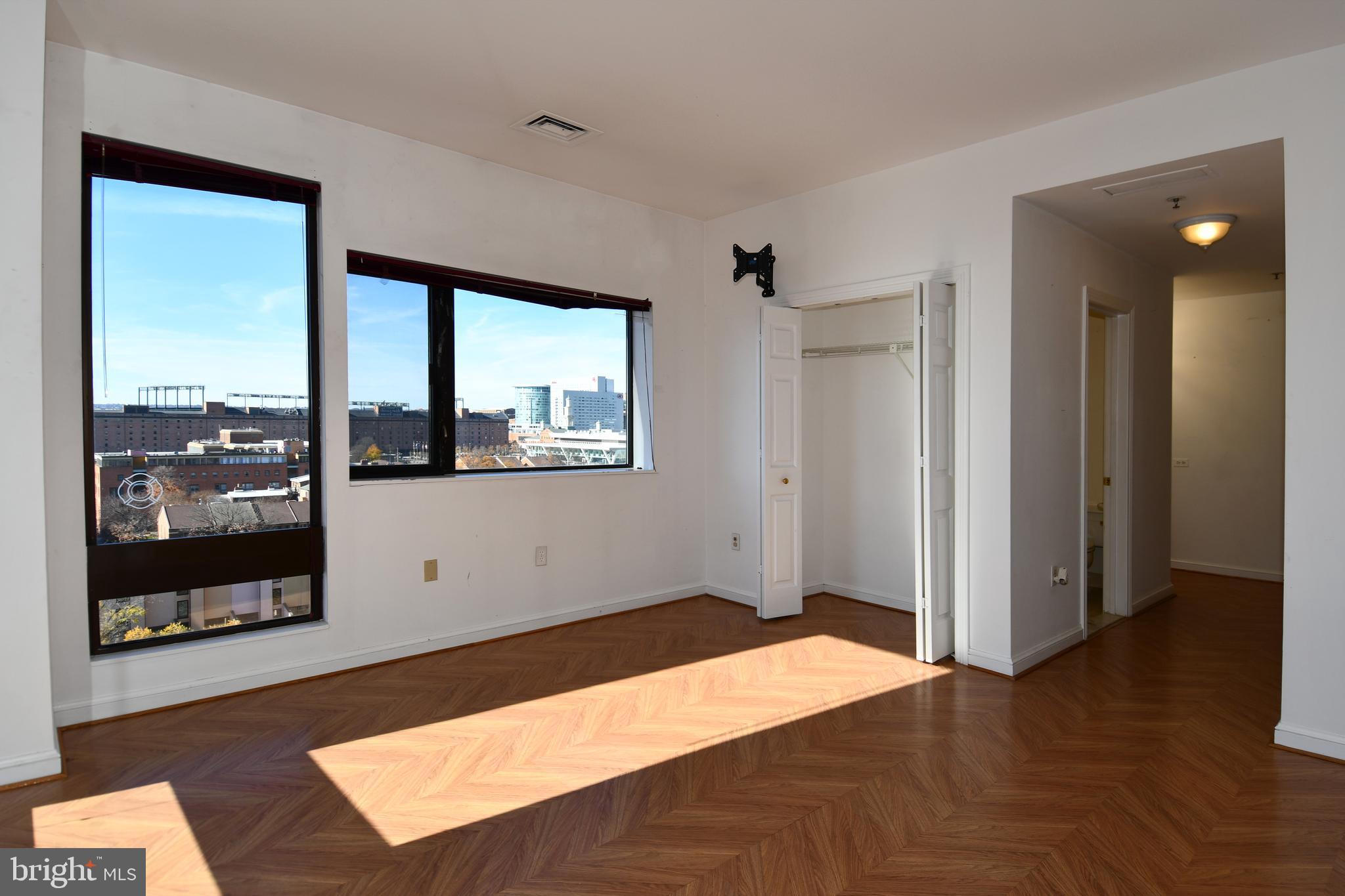 10 East Lee Street, Unit 809 Baltimore, MD 21202 - Photo 31 of 58 a bedroom with a bed and a window