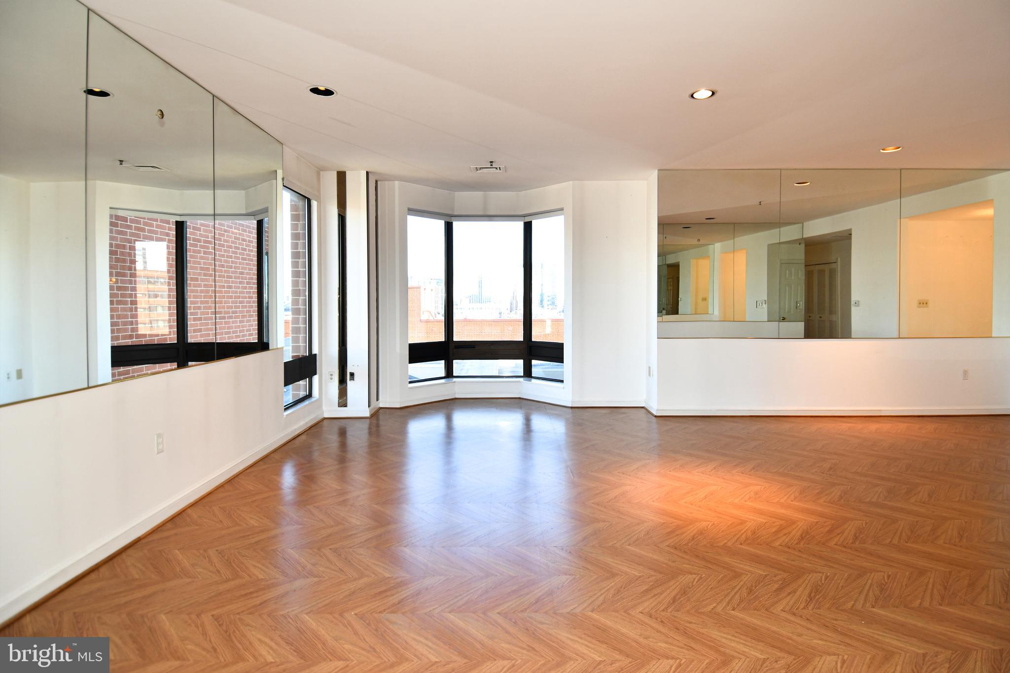 10 East Lee Street, Unit 809 Baltimore, MD 21202 - Photo 52 of 58 a view of an empty room with window and wooden floor