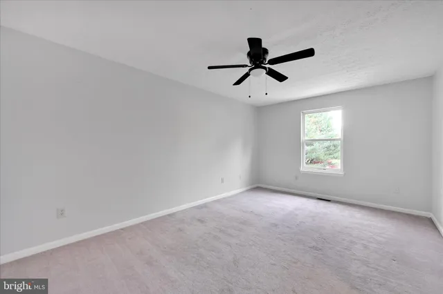 a view of empty room with ceiling fan
