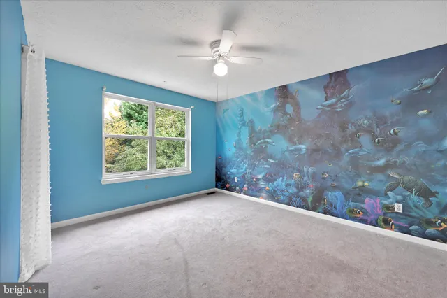 a view of a livingroom with a ceiling fan and window