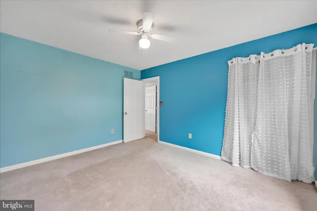 an empty room with closet and windows