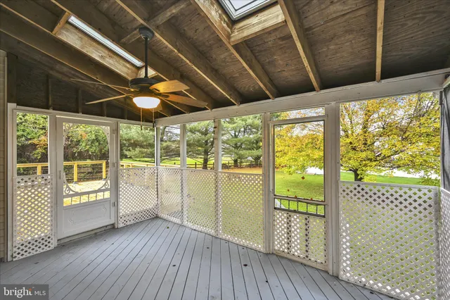 a view of an empty room with wooden floor and doors