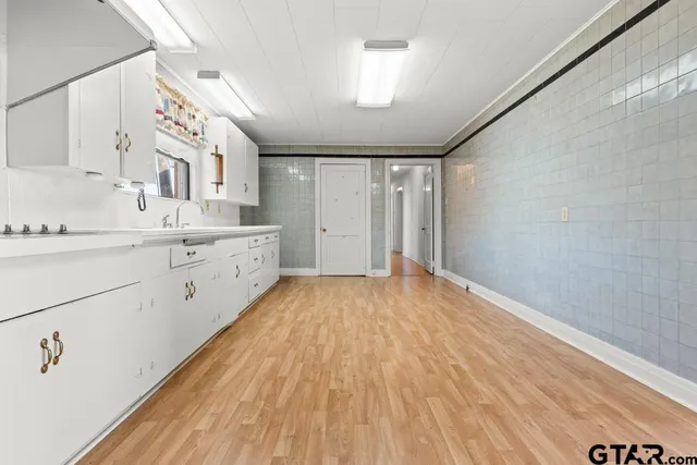 a view of a kitchen with wooden floor and electronic appliances