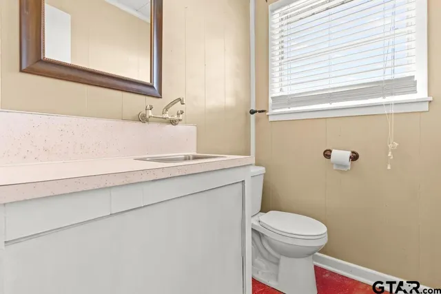 a bathroom with a toilet a sink and a window