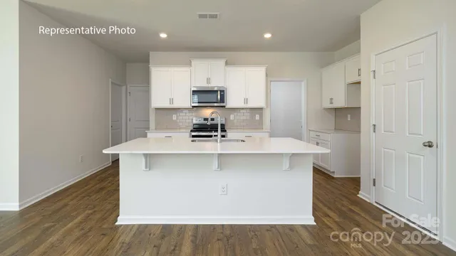 a kitchen with kitchen island a sink stainless steel appliances and cabinets