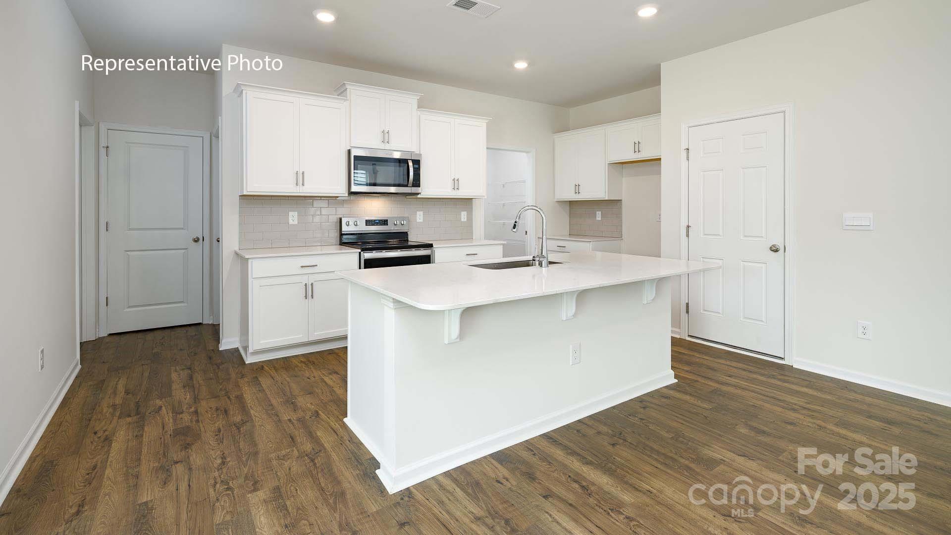 2671 Goose Fair Road Maiden, NC 28650 - Photo 5 of 28 a kitchen with stainless steel appliances a white stove top oven sink and cabinets