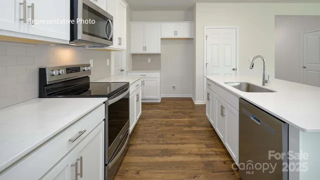 a kitchen with stainless steel appliances a sink stove top oven and cabinets