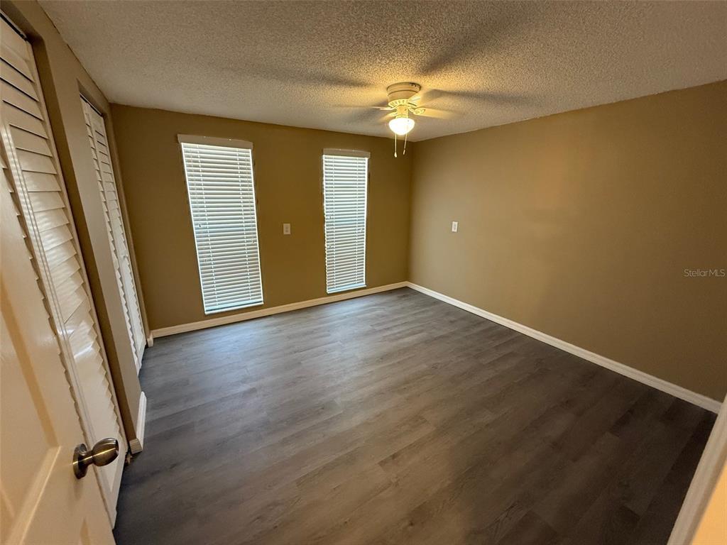 6104 Seabreeze Drive Port Richey, FL 34668 - Photo 11 of 25 an empty room with wooden floor and windows
