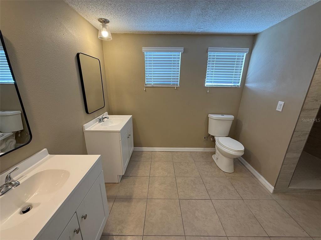 6104 Seabreeze Drive Port Richey, FL 34668 - Photo 13 of 25 a bathroom with a toilet sink and mirror
