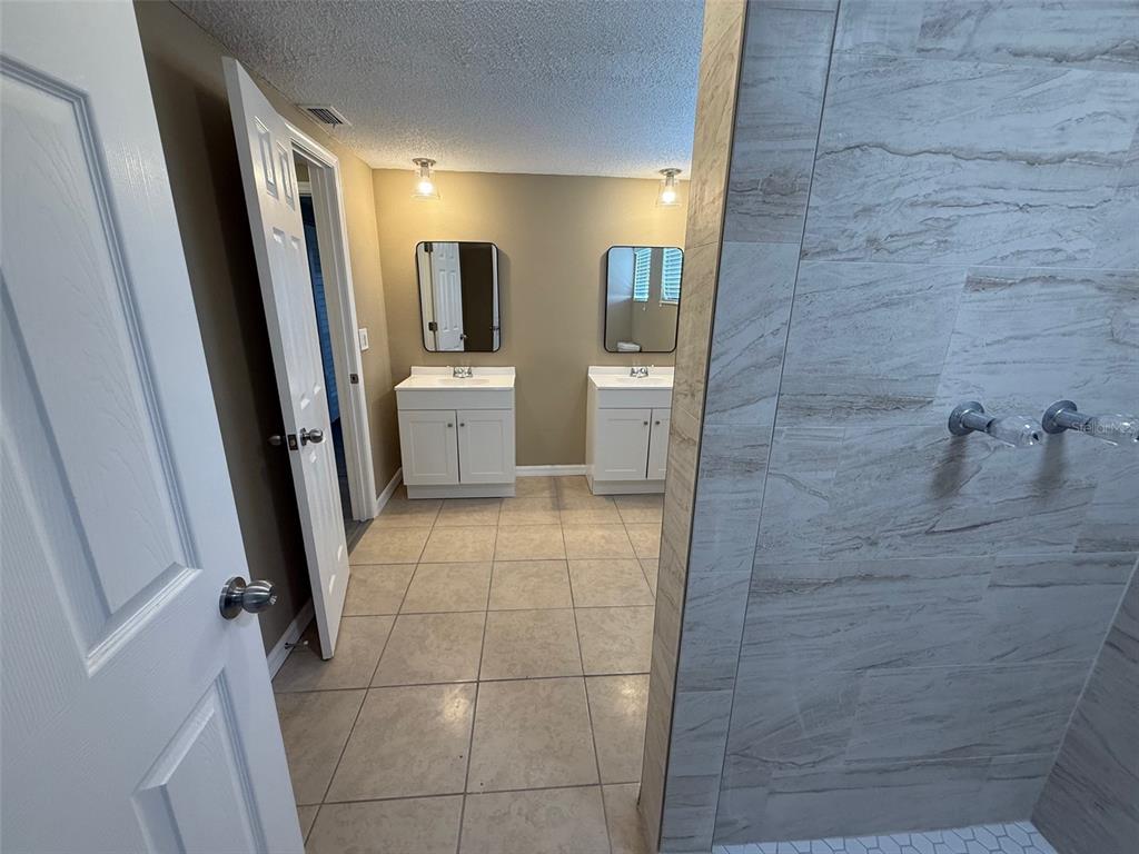 6104 Seabreeze Drive Port Richey, FL 34668 - Photo 14 of 25 a bathroom with a sink a toilet a mirror and shower