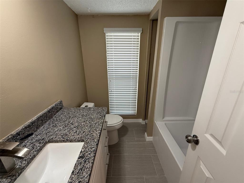 6104 Seabreeze Drive Port Richey, FL 34668 - Photo 16 of 25 a bathroom with a granite countertop sink and a mirror