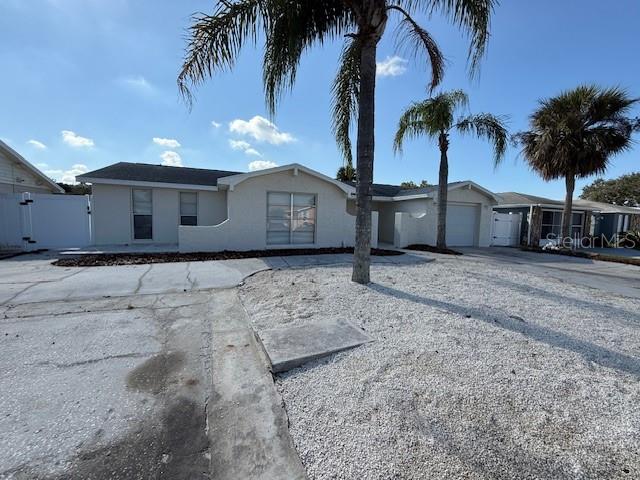 6104 Seabreeze Drive Port Richey, FL 34668 - Photo 25 of 25 a view of a house with a yard and palm trees