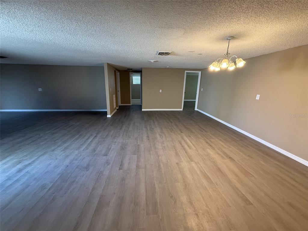 6104 Seabreeze Drive Port Richey, FL 34668 - Photo 3 of 25 wooden floor in an empty room with a window