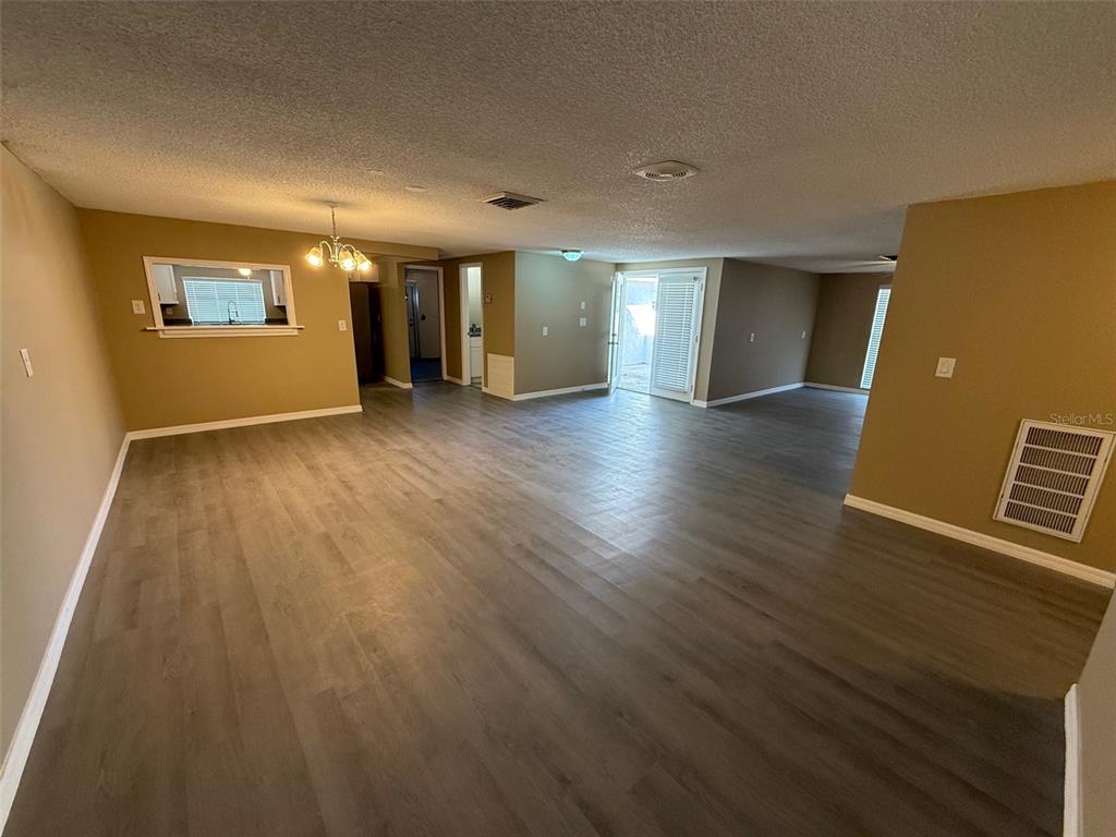 6104 Seabreeze Drive Port Richey, FL 34668 - Photo 4 of 25 wooden floor in an empty room with a window