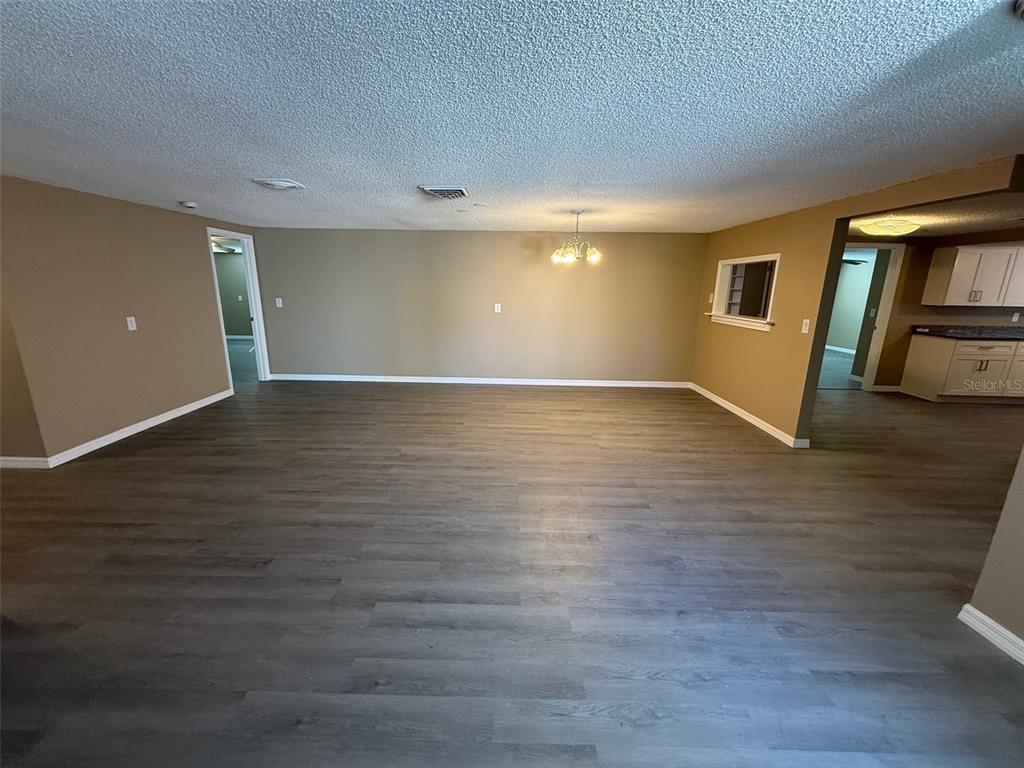 6104 Seabreeze Drive Port Richey, FL 34668 - Photo 5 of 25 a view of an empty room with wooden floor and a window
