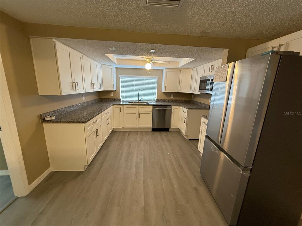 6104 Seabreeze Drive Port Richey, FL 34668 - Photo 6 of 25 a kitchen with a refrigerator a sink and dishwasher
