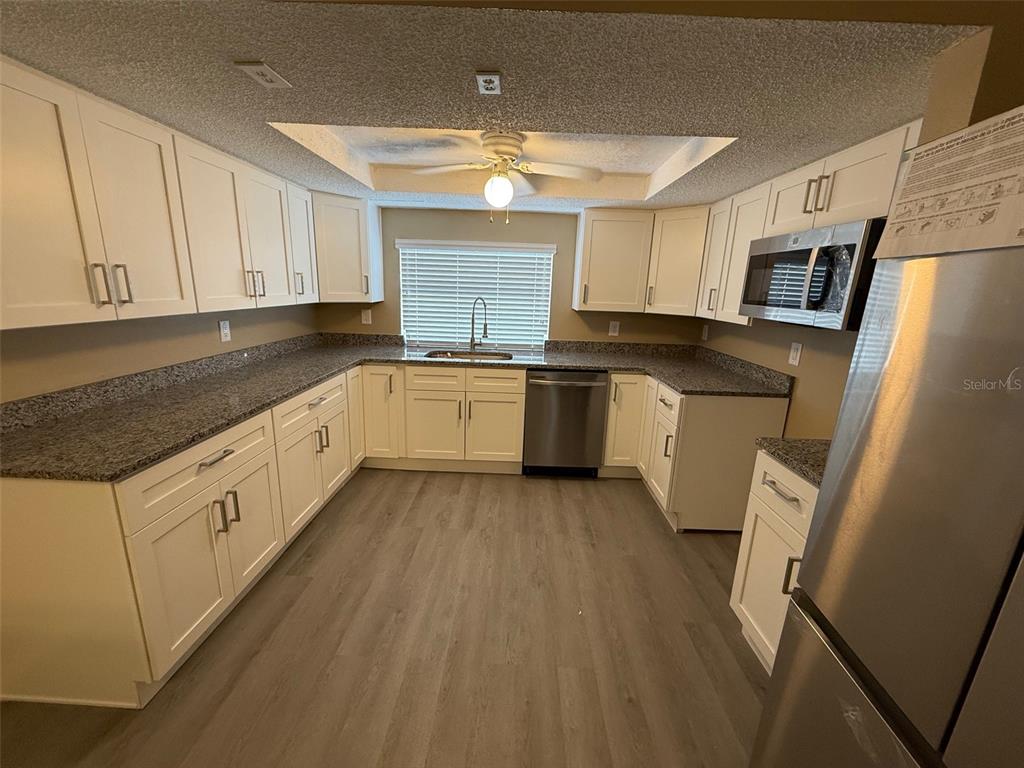 6104 Seabreeze Drive Port Richey, FL 34668 - Photo 7 of 25 a large kitchen with stainless steel appliances granite countertop a stove a sink dishwasher and a refrigerator