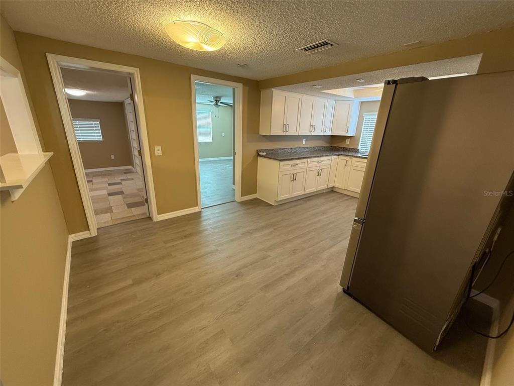 6104 Seabreeze Drive Port Richey, FL 34668 - Photo 8 of 25 a view of a kitchen with a sink refrigerator and wooden floor