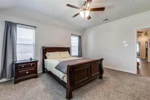 a spacious bedroom with a bed and a chandelier