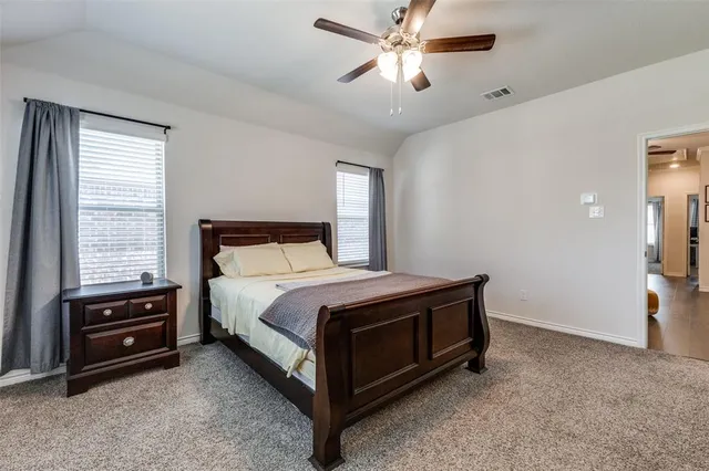a spacious bedroom with a bed and a chandelier