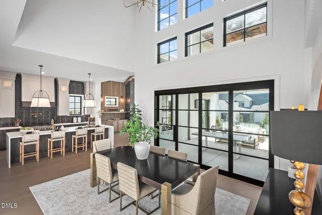 a large kitchen with a table chairs refrigerator and cabinets