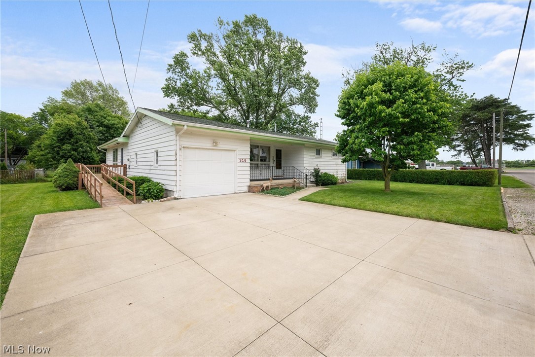 316 Deerwood Road Huron, OH 44839 - Photo 2 of 37 Single story home featuring attached one car garage and covered front porch. Extended driveway. Wooden ramp and deck on the side of the home.