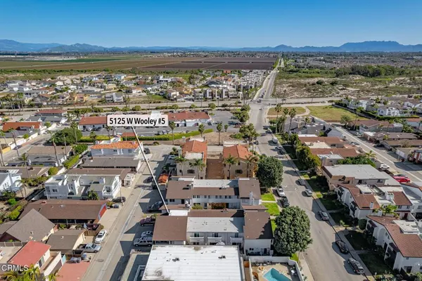 an aerial view of a city with lots of residential buildings and mountain view in back