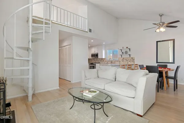 a living room with furniture a dining table and kitchen view