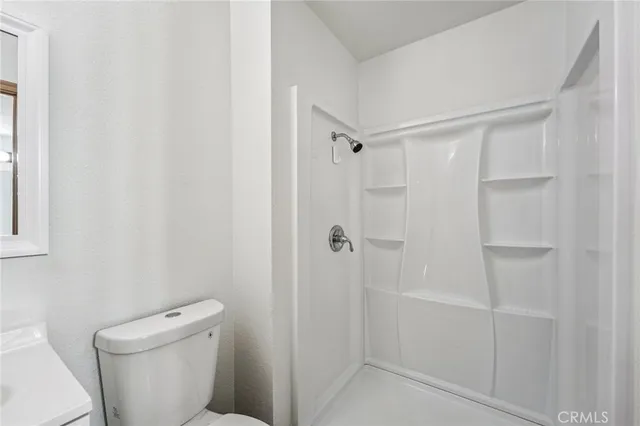 a bathroom with a toilet and a shower