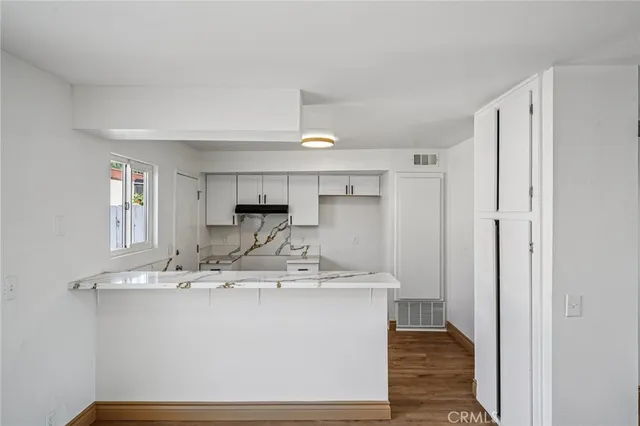 a room with kitchen island a sink stainless steel appliances and cabinets