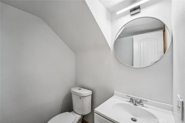 a bathroom with a sink mirror and toilet