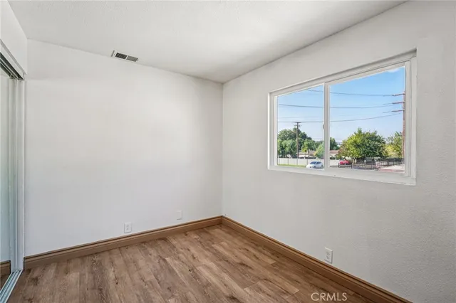 a view of small space with wooden floor and a window
