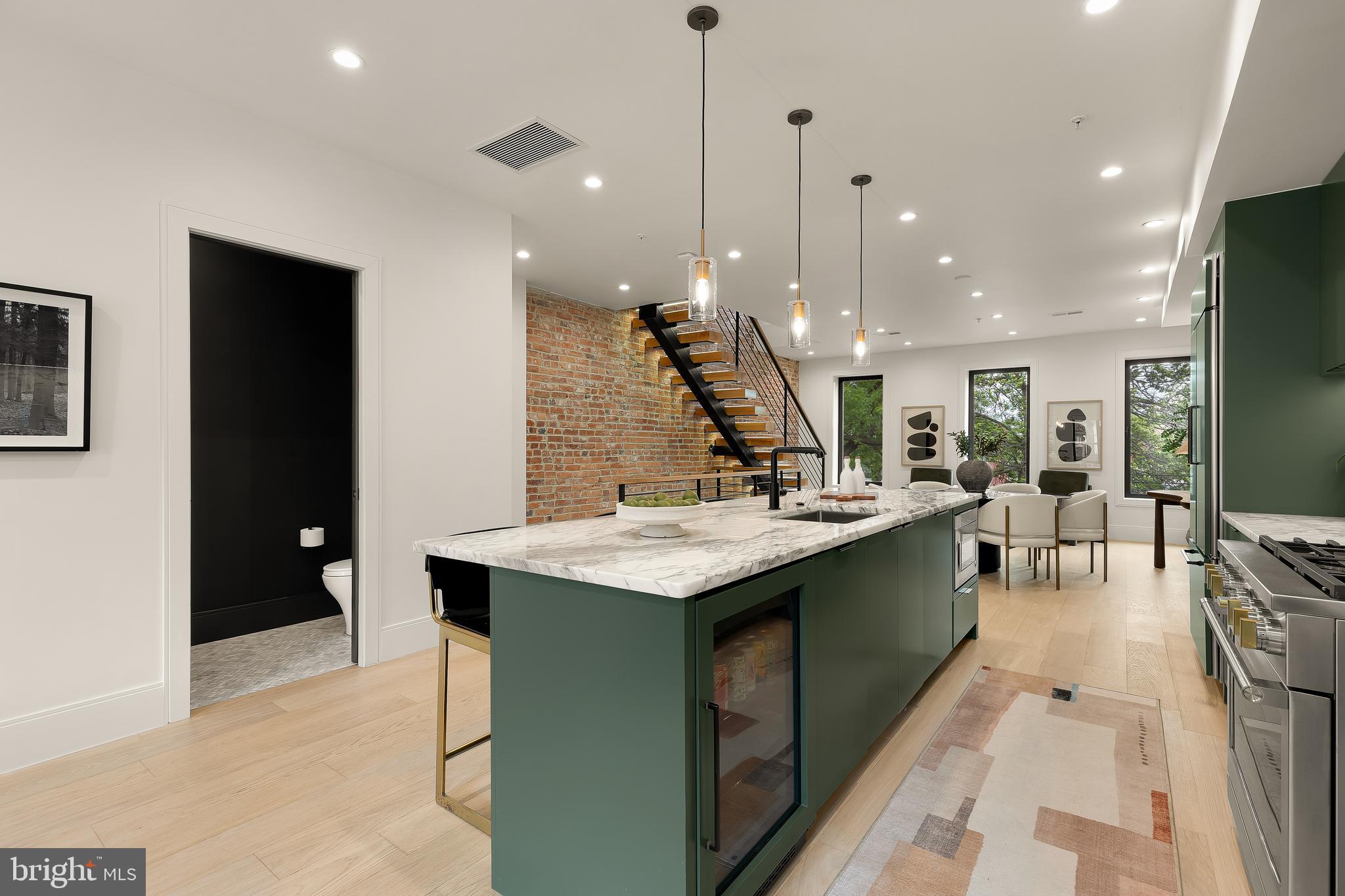 2534 11th Street Northwest, Unit 2 Washington, DC 20001 - Photo 12 of 50 a large kitchen with kitchen island a sink a counter top stainless steel appliances and a dining table