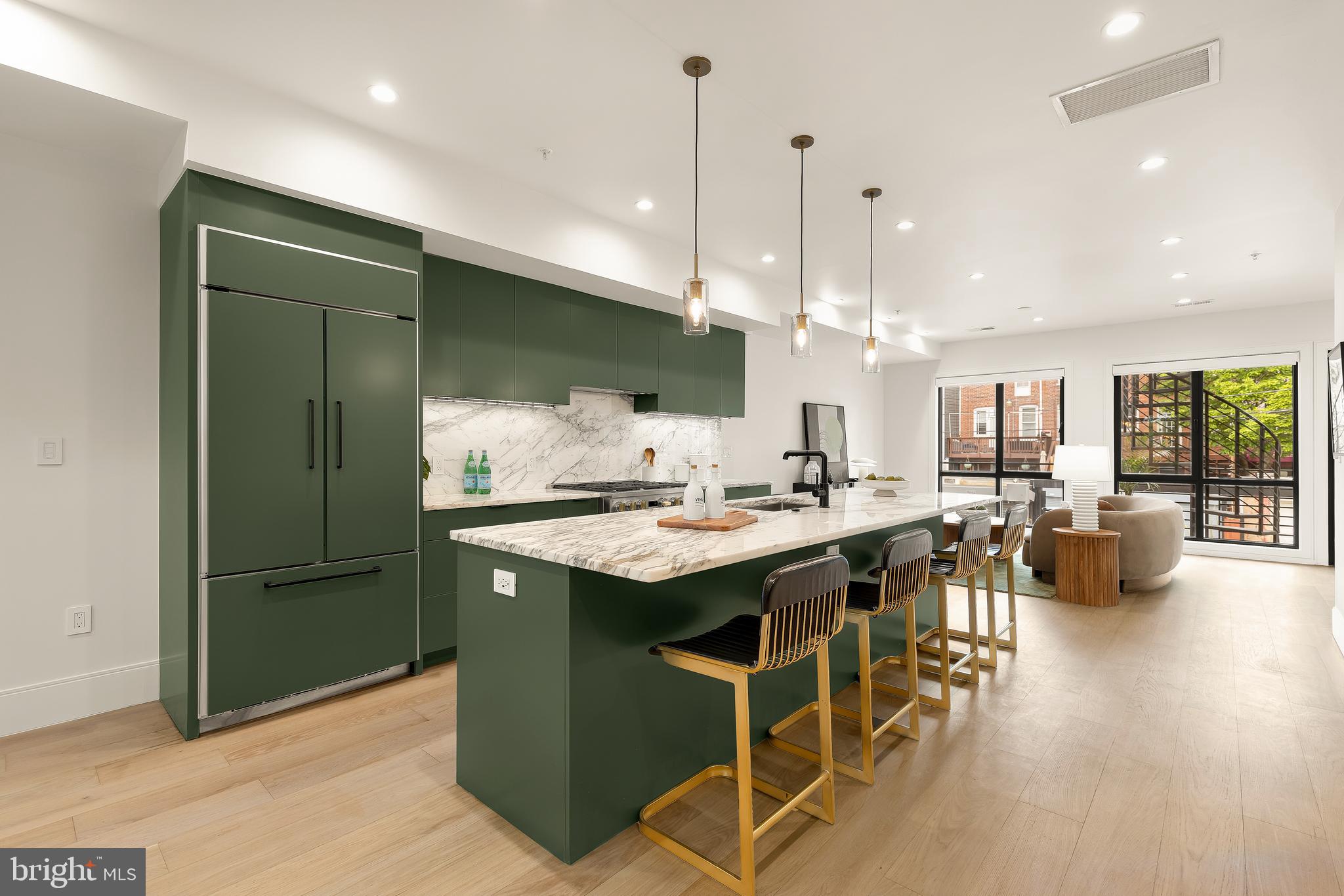 2534 11th Street Northwest, Unit 2 Washington, DC 20001 - Photo 7 of 50 a kitchen with stainless steel appliances granite countertop a kitchen island a stove a refrigerator a sink a dining table and chairs with wooden floor