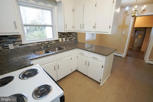 a kitchen with a stove and white cabinets