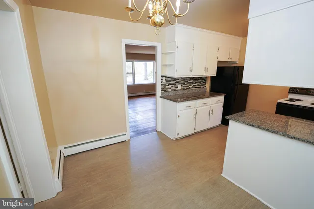 a kitchen with granite countertop white cabinets and white appliances