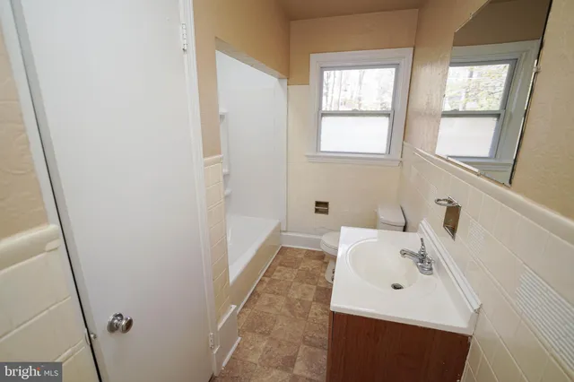 a bathroom with a sink a bathtub and a window