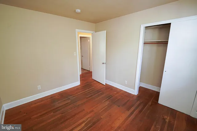 an empty room with wooden floor and closet