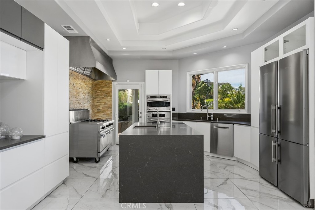 22 Cresta Del Sol San Clemente, CA 92673 - Photo 15 of 70 Commercial 6 burner gas stove with side griddle and two ovens, not to mention a third oven at the end of the kitchen with microwave above, vegetable sink in the island for easy counter space pre and a wonderful 4 door refrigerator, commercial grade hood over the stove with an over abundance of cabinets and counter space.