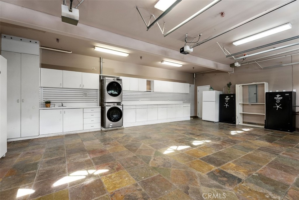 22 Cresta Del Sol San Clemente, CA 92673 - Photo 54 of 70 Three car garage with washer & dryer, sink, whole-house water purification system, reverse osmosis drinking water, wired for ADT security sytem, and plenty of cabinet space, drawers, extra refrigerator, lighting and slate flooring. This garage is finished. One safe can remain, one removed, up to the buyer.