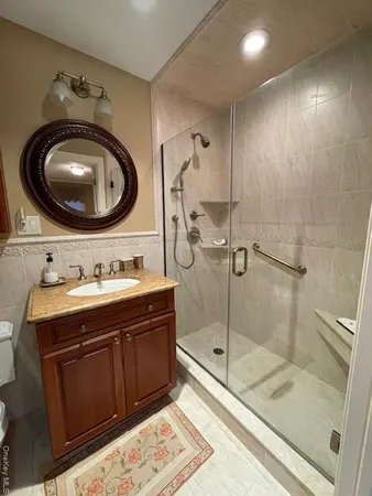 a bathroom with a granite countertop sink and a mirror