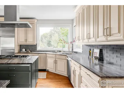 a kitchen with stainless steel appliances granite countertop a stove a sink and white cabinets