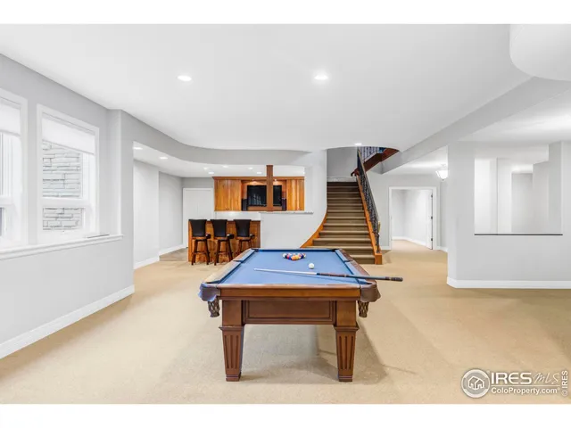 a room with pool table and windows