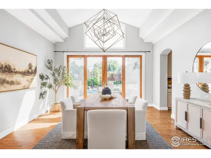a dining room with furniture large windows and a chandelier