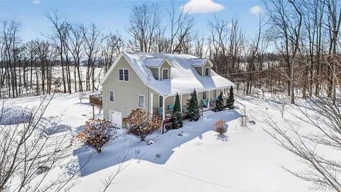 a view of a house with a yard covered in snow