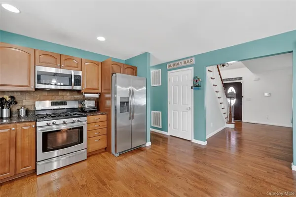a kitchen with stainless steel appliances a refrigerator and a stove top oven
