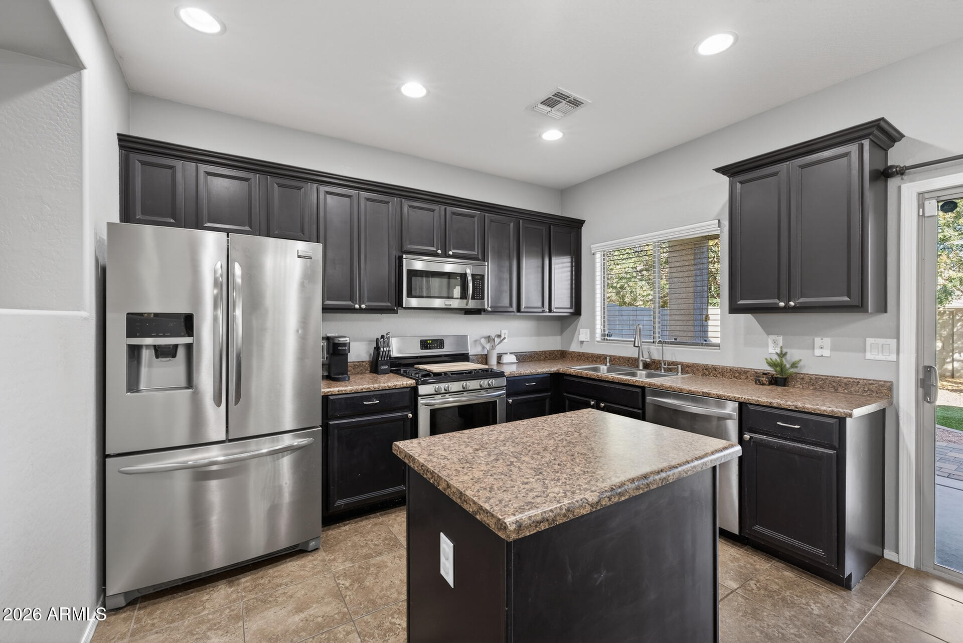 724 West Trellis Road Queen Creek, AZ 85140 - Photo 9 of 46 a kitchen with a sink stove and refrigerator