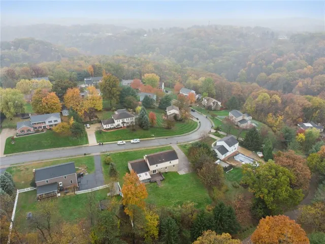 an aerial view of a house with garden space seating area and car parked